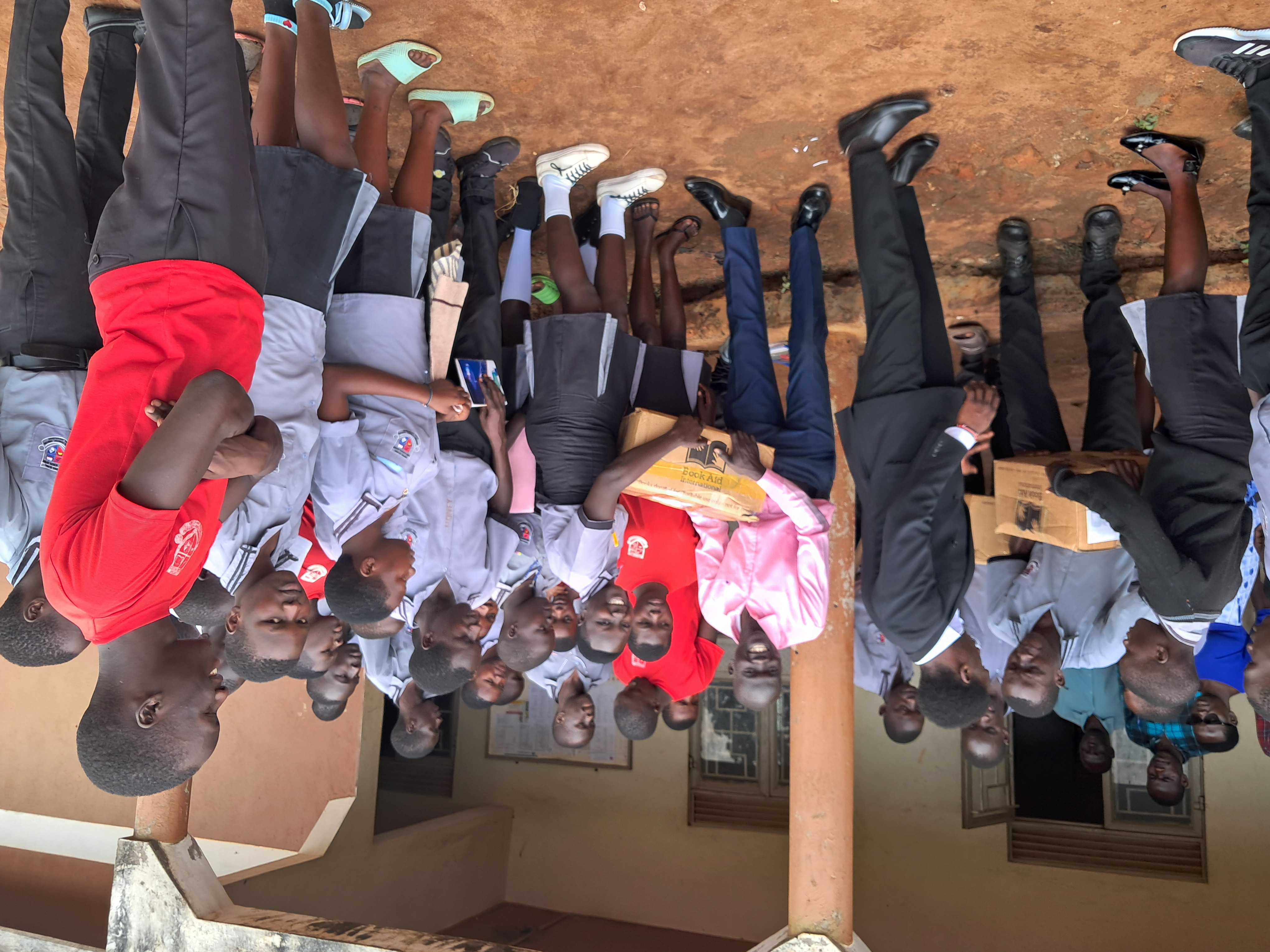 Distributing scholastic materials at an underserved and underpriviledged Secondary School, Myene village, Kamdini Sub-county, Oyam District.