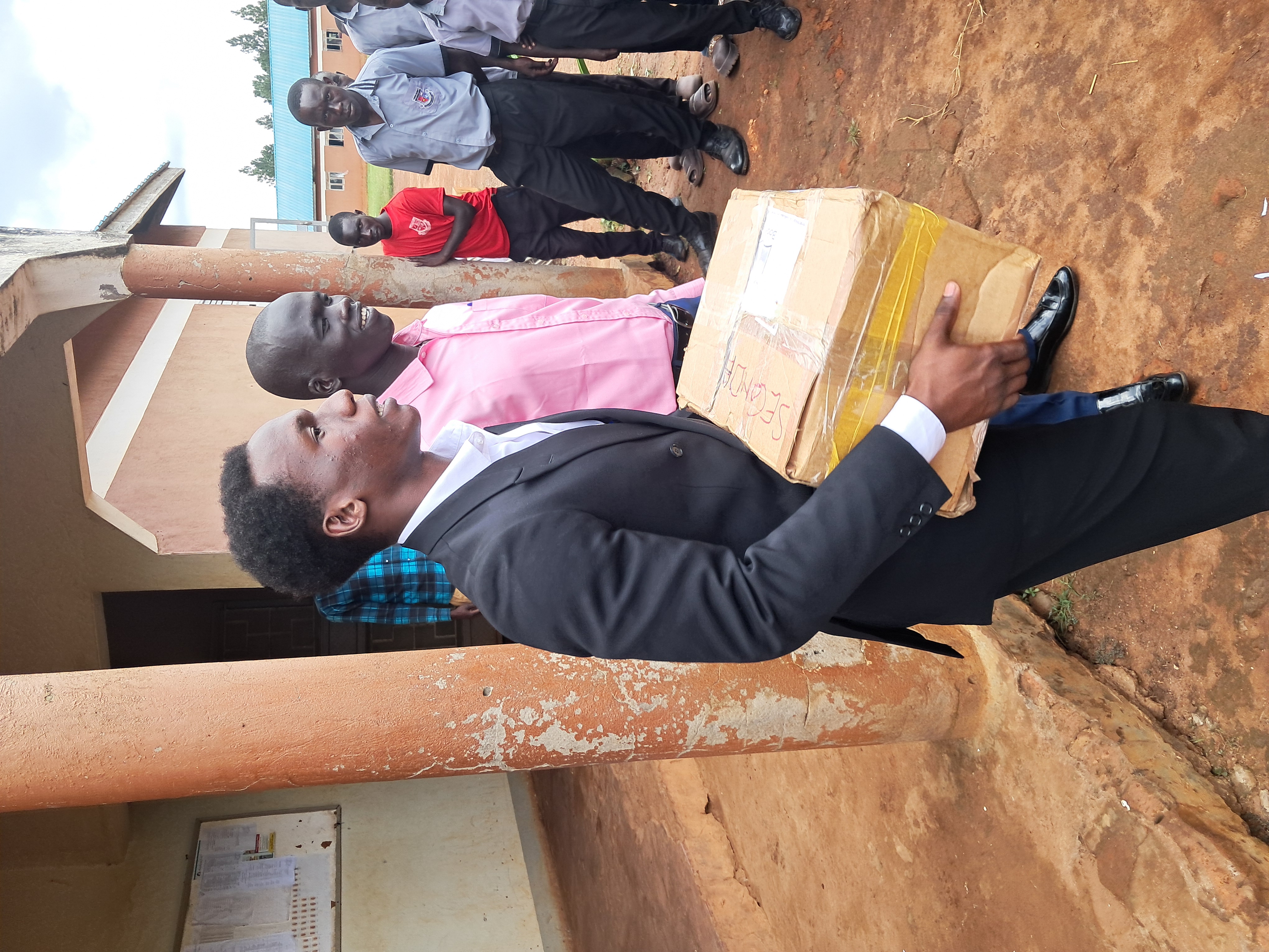 Distributing scholastic materials at an underserved and underpriviledged Secondary School, Myene village, Kamdini Sub-county, Oyam District.