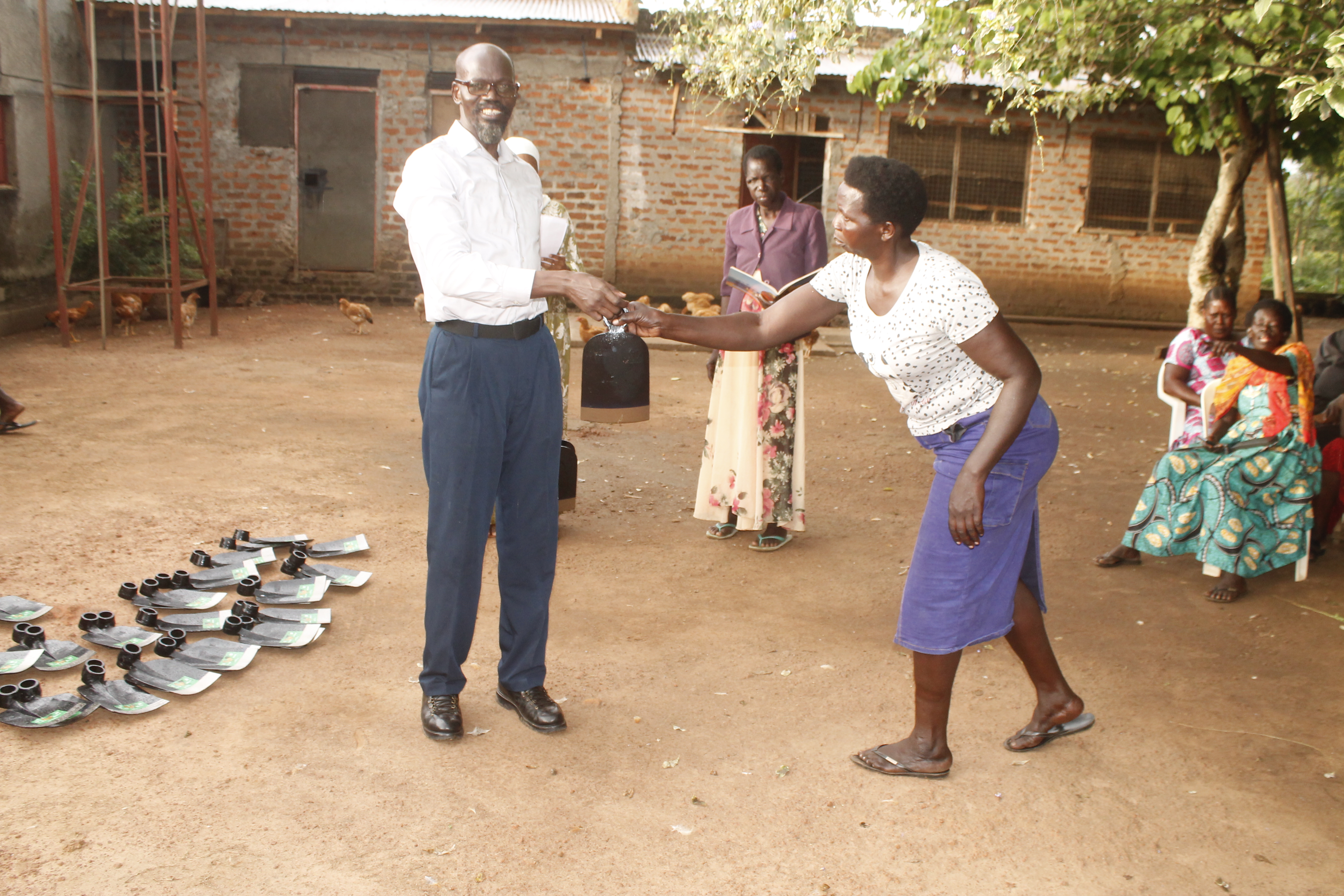 Distributing farming materials to community women in Anywalonino village, Lira.