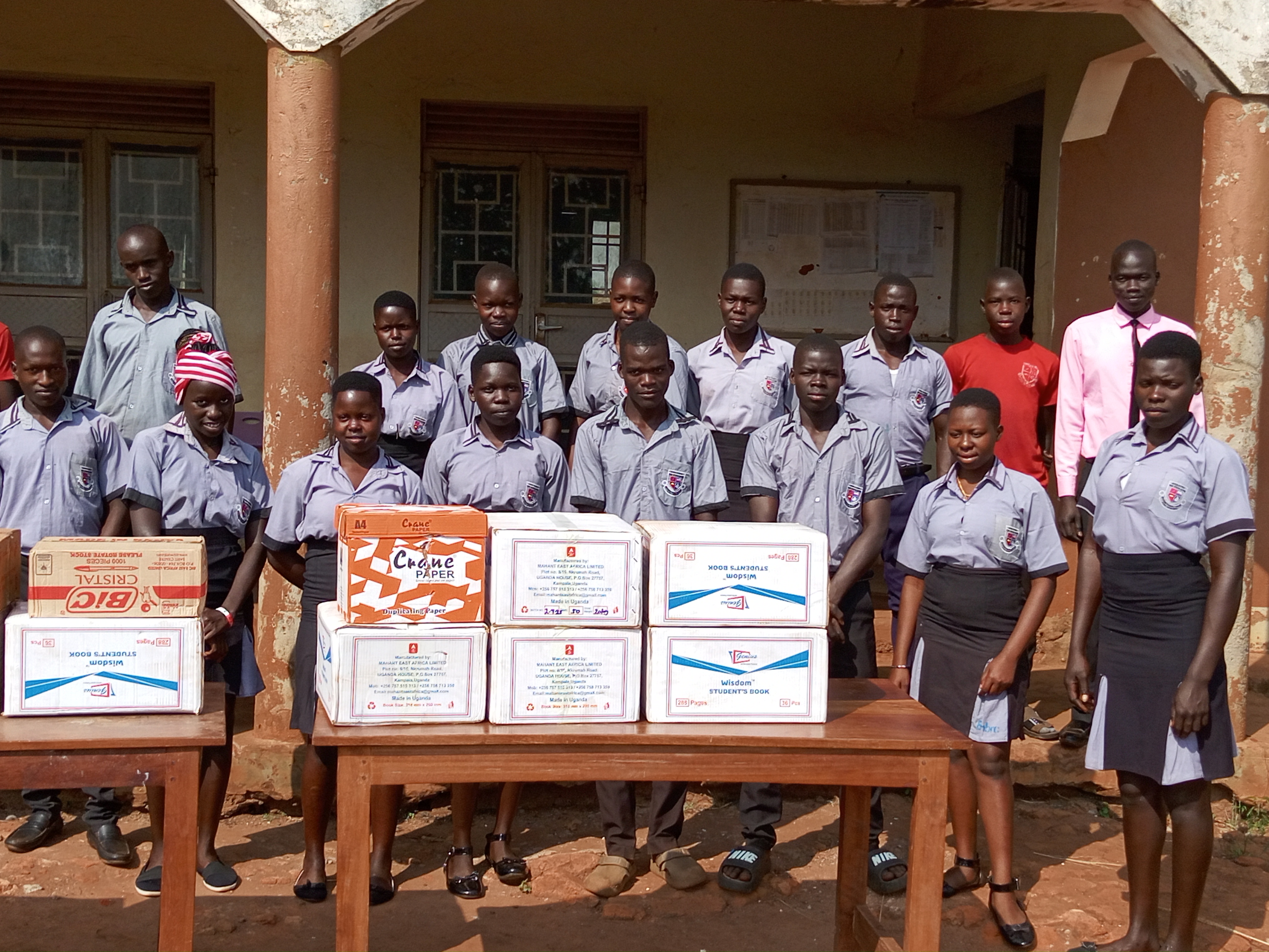 Distributing scholastic materials at an underserved and underpriviledged Secondary School, Myene village, Kamdini Sub-county, Oyam District - July 2025.